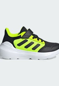 Schwarze und neongrüne Sportschuhe mit einem Mesh-Obermaterial, einem Klettverschluss, drei schwarzen Streifen und einer weißen gepolsterten Sohle, die mit "CLOUDFOAM" beschriftet ist.
