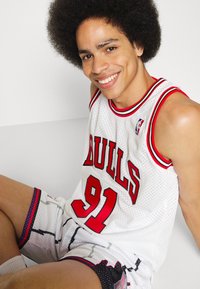Jerseiul alb de baschet cu accente roșii și negre, având inscriptionat "BULLS" și "91" pe față, completat cu șorturi cu un model asortat.