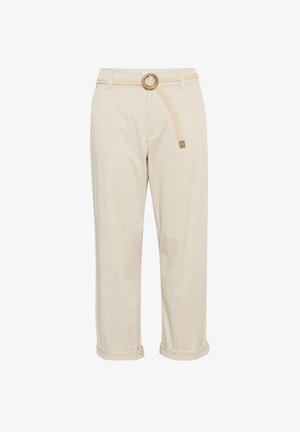 Beige kokvilnas bikses ar pīts jostu, kurai ir apļveida sprādze. Bikses piedurknes ir sarullētas uz apakšējā mala, lai nodrošinātu brīvu piegriezumu.