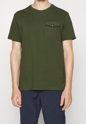 T-shirt en coton vert olive avec manches courtes, col rond et une poche poitrine avec un bouton-pression. Design simple et sans fioritures.