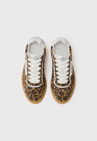Baskets à imprimé léopard en suède marron, lacets blancs et semelles en caoutchouc. Marque visible sur le côté et les semelles intérieures.
