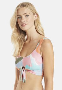 Kleurrijke bikinitop met grote bloemenpatronen in roze, blauw en groen. Het heeft een ronde halslijn en is in het midden vooraan geknoopt.