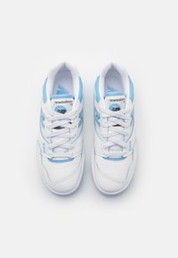 Weiße Sneaker mit blauen Akzenten, aus Leder gefertigt, mit runder Zehenform, Schnürverschluss und strukturierter Sohle. Markenlogo an der Seite.