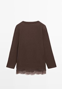 Brown long-sleeve top with a round neckline and lace trim at the hem. Soft texture, relaxed fit, and subtle design.
