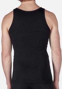 Canotta nera con un design aderente, realizzata in tessuto morbido. Presenta spalline larghe e un collo rotondo, caratterizzata da una texture semplice.
