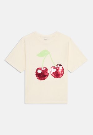 Cream-colored short-sleeve t-shirt with a large sequined red cherry design and green stems and leaves on the front.