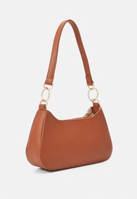 Bolso de hombro de cuero marrón con un diseño curvado, acentos de hardware dorado y cierre de cremallera, que cuenta con una correa ajustable y delgada.