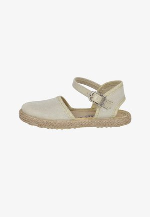 Sandalia espadrille de lona beige con puntera cerrada, tira en el tobillo, hebilla plateada y suela trenzada de yute.