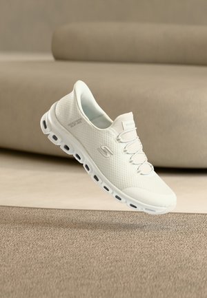 White sneakers with a textured mesh upper, elastic laces, and cushioned outsole. Lightweight design with visible air cushioning in sole.