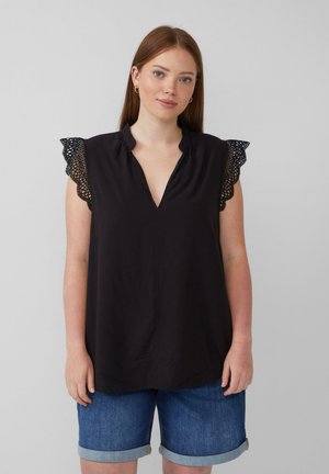 Blouse noire avec un col en V et une bordure en dentelle sur les manches. Tissu doux, coupe décontractée, associée à un short en denim.