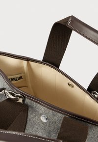 Szürke vászontáska barna bőr részletekkel és fogantyúkkal, bézs belsővel, ezüst színű fém kiegészítőkkel és gombos záródással. Belső része elválasztókkal bélelt.