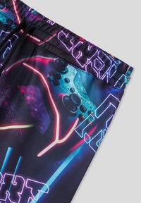 Pantaloni da gioco multicolori con grafica di un controller digitale, vita elasticizzata e accenti neon dinamici su uno sfondo scuro.
