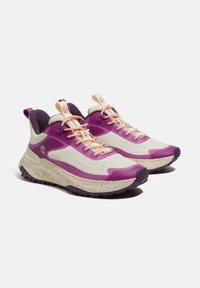Scarpe sportive viola e crema con tomaia in rete, suola testurizzata, lacci a contrasto e suola intermedia maculata. Progettate per il comfort e la trazione.