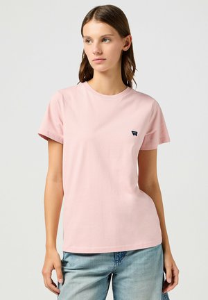 Rosa Baumwoll-T-Shirt mit Rundhalsausschnitt, kurzen Ärmeln und einem kleinen dunklen Logo auf der linken Brust. Lässige Passform und weicher Stoff.