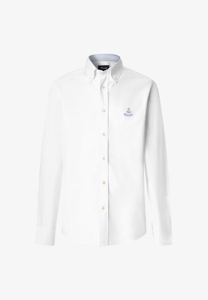 Camicia bianca a maniche lunghe con bottoni e colletto con bottoni, con piccolo emblema ricamato blu sul lato sinistro del petto.