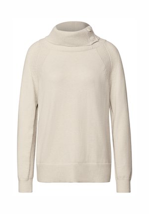 Lichtbeige trui met een hoge geribbelde kraag en knoopdetails. Het lichaam heeft een gladde stof, terwijl de schoudernaden textuuraccenten hebben.