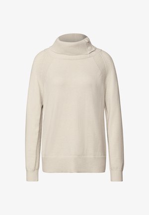 Suéter de un tono beige claro con un alto cuello acanalado y detalles de botones. El cuerpo presenta una tela suave, mientras que las costuras de los hombros tienen acentos texturizados.