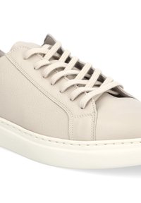 Jasno beżowe skórzane trampki o gładkim wykończeniu, okrągłym nosku oraz sześciokanalikowym systemie sznurowania. Biała gumowa podeszwa i subtelne detale przeszyć.