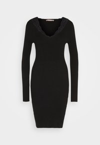 Robe moulante noire en maille à manches longues avec encolure en V bordée de dentelle noire, taille cintrée et ourlet longueur genou.