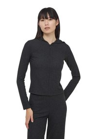 Felpa nera con zip, a coste, con maniche lunghe e design aderente. Presenta un cappuccio e una lunghezza corta, realizzata in materiale morbido.