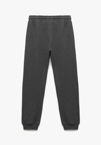 Grå sweatpants lavet af blødt stof, med elastisk talje og tætsiddende manchetter ved anklerne. Simpelt design uden mønstre eller accenter.