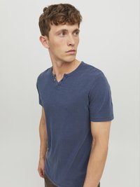 Granatowa koszulka z krótkim rękawem, wykonana z miękkiej tkaniny, z dekoltem henley i dwoma guzikami oraz luźnym krojem. Gładka tekstura, minimalistyczny design.