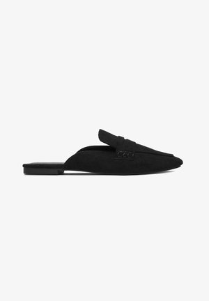 Black suede flat mule with pointed toe, backless design, and decorative strap across the top, shown on a white background.