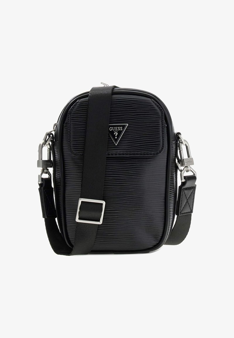 Fekete texturált válltáska állítható pánttal, háromszög alakú Guess logóval és ezüst színű fém kapcsokkal, fehér háttéren.