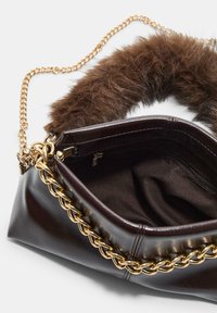 Sac à main en cuir marron avec une chaîne dorée et une poignée en fourrure. L'intérieur présente une doublure en tissu sombre et une poche zippée. Texture lisse, forme structurée.