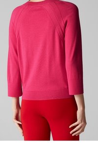 Fuchsia trui met driekwartmouwen, geribbelde manchetten en zoom, met een gladde textuur en raglannaaddetails.