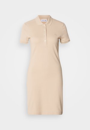 Beežipunane polosärkidest kleit pehmest kangast, millel on kolme-nupu plastron, lühikesed varrukad ja õrnalt tikitud logo rinnal.