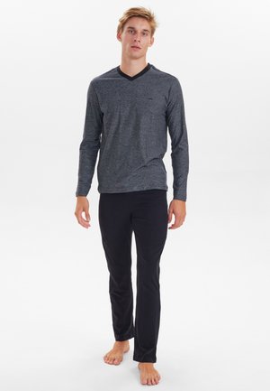 Camisa de manga larga de color gris oscuro jaspeado con cuello en V y una leve textura, combinada con pantalones negros de pierna recta.