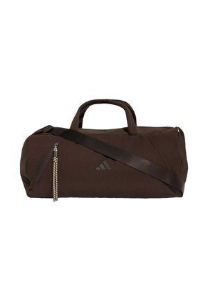 Sac polochon cylindrique marron foncé avec poignées, bandoulière réglable, poche latérale zippée et petit logo à l'avant.