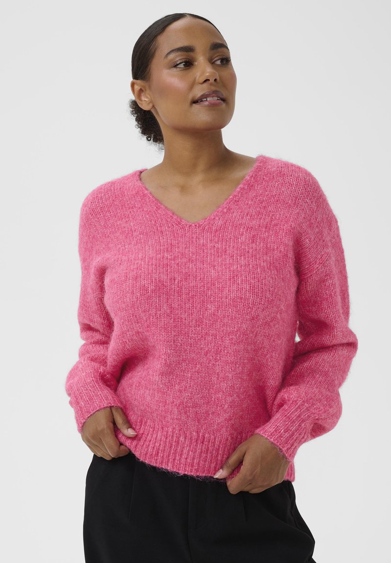 Suéter oversize de cuello en V en color rosa brillante, hecho de hilo esponjoso. Cuenta con puños y dobladillo acanalados, con un ajuste relajado y textura suave.