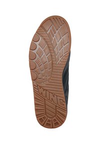 Suola della scarpa con un design in gomma testurizzata marrone, caratterizzata da motivi circolari e lineari, con il marchio "EWING" in evidenza sul lato.