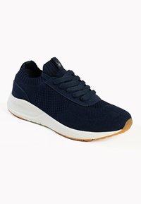 Sneakers a maglia di colore blu navy con un design flessibile, caratterizzati da superfici testurizzate, lacci piatti e una suola intermedia bianca con una suola in gomma naturale.