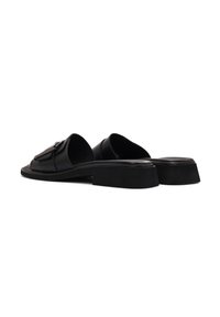 Sandalias de piel negra deslizantes con suela plana, que cuentan con una correa ancha y herrajes decorativos en la parte superior. Textura suave con un diseño minimalista.