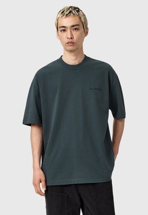 Dunkelgrünes, oversized T-Shirt aus Baumwolle mit rundem Halsausschnitt und kurzen Ärmeln. "ALLSAINTS"-Logo auf der linken Brust aufgedruckt.