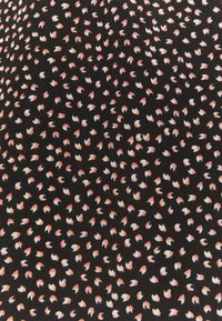 Černá látka s rozptýleným vzorem malých, listovým tvarům v bílé barvě s broskvovými hroty. Textura vypadá hladce a lehce.