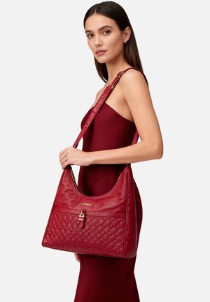 Borsa sintetica trapuntata rossa con una sezione superiore liscia e dettagli in oro. Presenta una tracolla larga con logo.