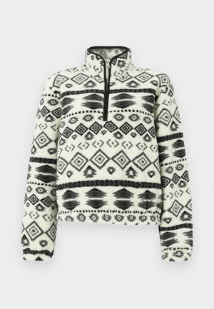 Fleece pullover with half-zip collar, featuring a black and white geometric pattern on soft, textured fabric. Cropped design with long sleeves.