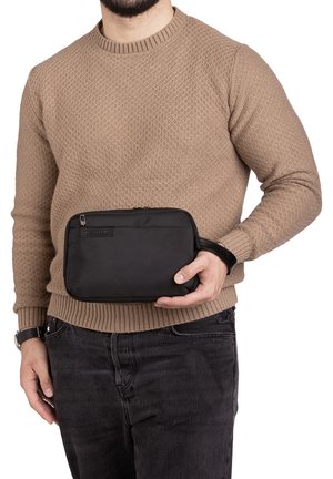 Busta in tessuto nero con texture, tenuta in una mano. Presenta un piccolo anello per il trasporto. Design compatto adatto per l'organizzazione.
