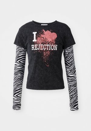 Must mustaheline t-särk lühikeste varrukatega, millel on valge ja roosa "I ❤️ REJECTION" graafika, koos pikkade must-valgete lõvidega triipudega varrukatega.
