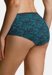 Slip di cotone color turchese con un motivo floreale nero e un cinturino a contrasto. Il design presenta una vestibilità a copertura totale e una texture morbida.