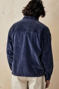 Sacou din bumbac închis de culoare navy, cu textură cu nervuri verticale, manșete cu nasturi și guler. Are un croi lejer și detalii pe spate.