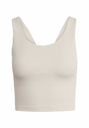 Top court beige clair fabriqué en tissu lisse et extensible. Présente des bretelles larges et un décolleté arrondi.