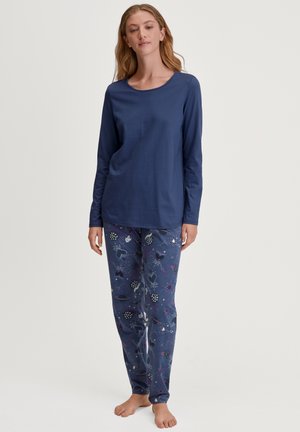 Marineblaues Langarmoberteil mit rundem Ausschnitt, kombiniert mit gemusterten Schlafanzughosen, die verschiedene Formen und Farben auf einem dunklen Hintergrund zeigen.