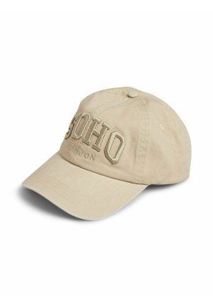 Bež bomba kapa iz bombaža z ukrivljenim šiltom, na sprednji strani z dvignjeno vezenino z napisom "SOHO" in manjšim napisom "LONDON".