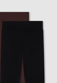 Dwie pary legginsów: jedne czarne, a drugie ciemnobrązowe, obie z szerokimi, miękkimi paskami w talii oraz gładkim, elastycznym materiałem.