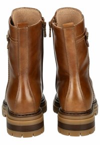 Bottines en cuir marron avec une finition lisse, fermeture éclair et semelle robuste avec un design en relief pour une bonne adhérence. Coutures détaillées.